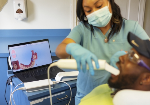 Masked dental team member scanning patient's mouth