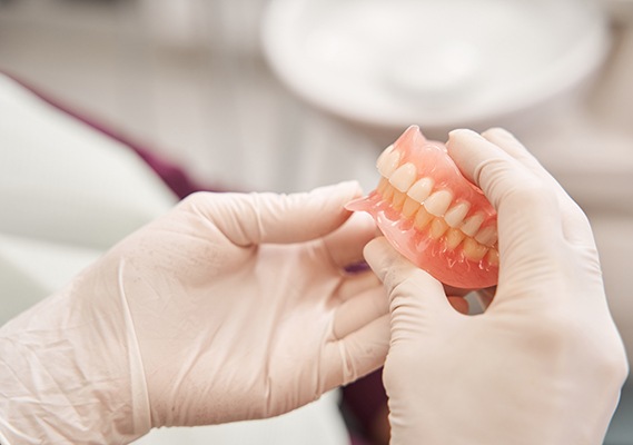 Hands holding dentures in Springfield