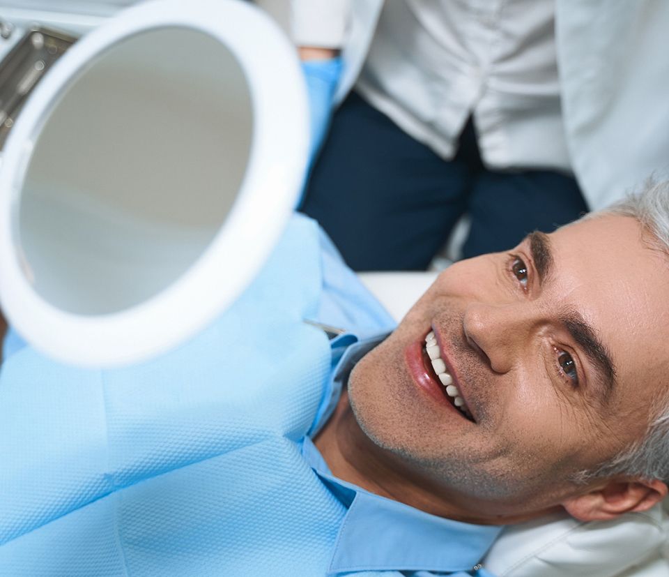 A man smiling at his newly restored teeth