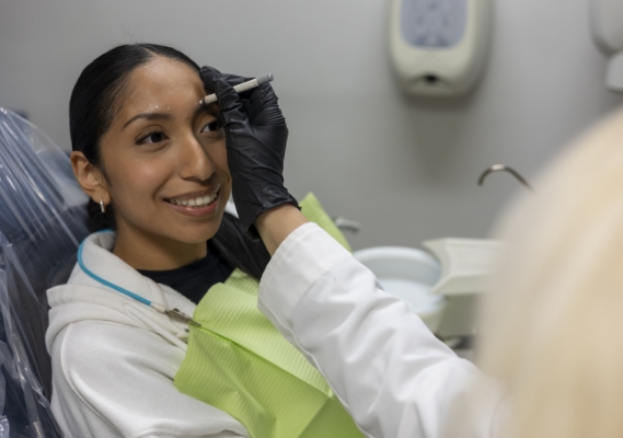 Woman receiving BOTOX injection in forehead