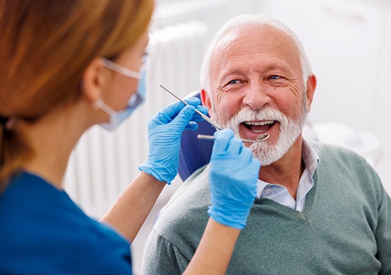 Man smiles at dental hygienist