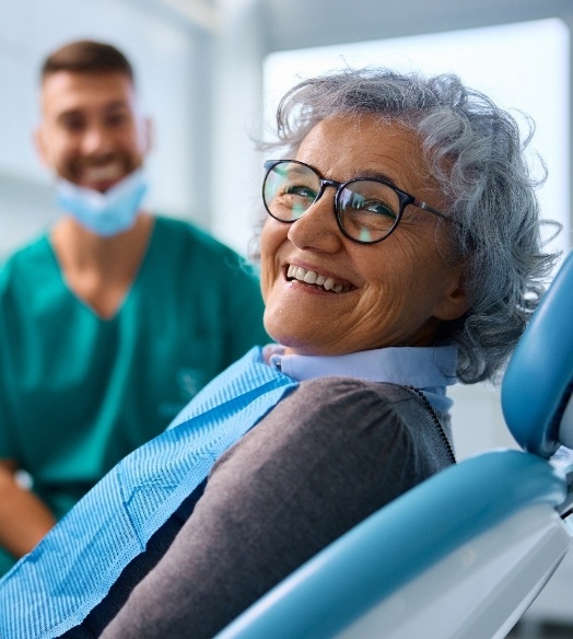 Bearded man smiling and adjusting his glasses