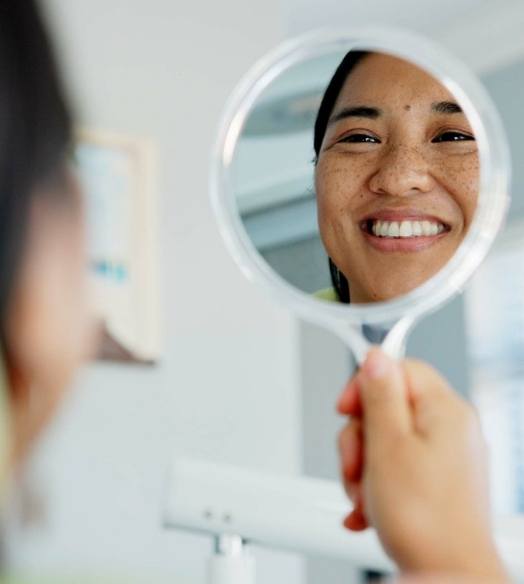 Bearded man smiling and adjusting his glasses