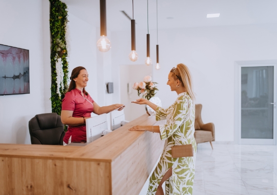 Woman checking in at the front desk of a dental office